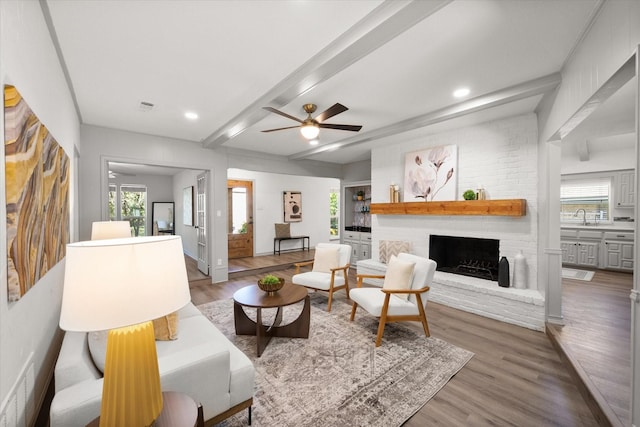 626 Pebblecreek Dr, Garland, TX 75040 - living room featuring wood finished floors, a ceiling fan, a fireplace, beam ceiling, and recessed lighting