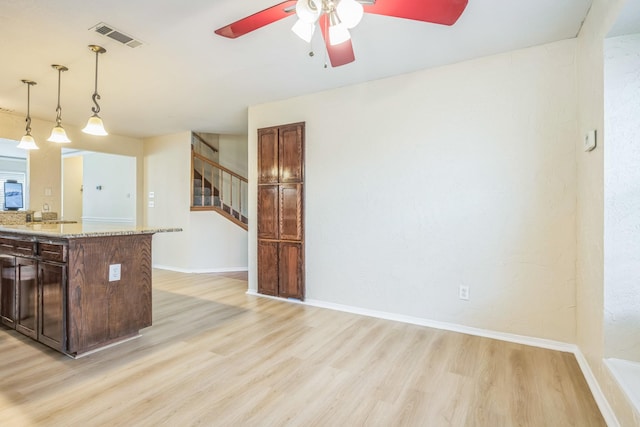7413 Dana Ln, North Richland Hills, TX 76182 - kitchen featuring light wood-style floors, ceiling fan, light stone countertops, baseboards, and decorative light fixtures