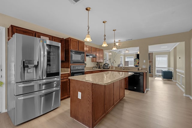 7413 Dana Ln, North Richland Hills, TX 76182 - kitchen with black appliances, light wood-style floors, a kitchen island, decorative light fixtures, and light stone countertops