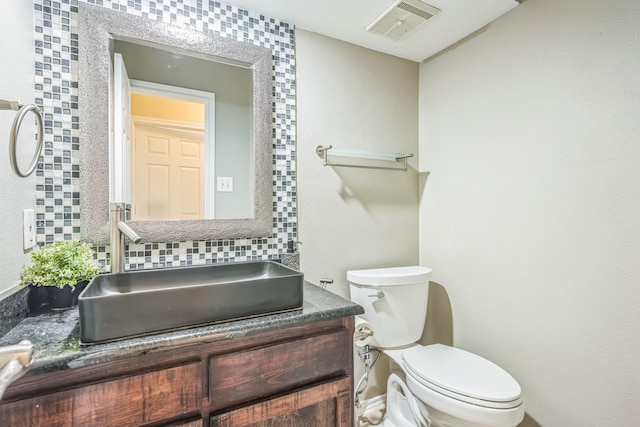 7413 Dana Ln, North Richland Hills, TX 76182 - bathroom featuring toilet, vanity, and decorative backsplash