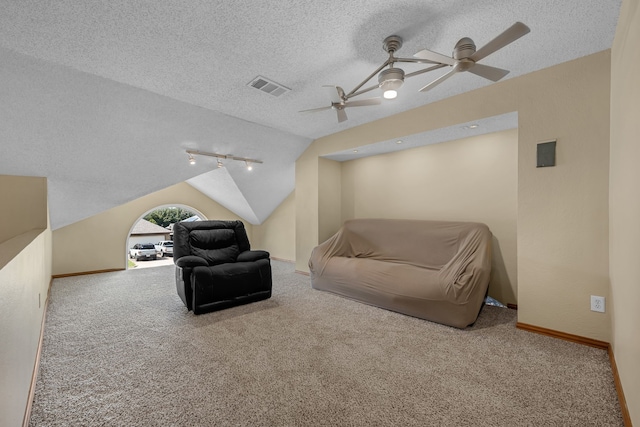 7413 Dana Ln, North Richland Hills, TX 76182 - living area featuring a textured ceiling, vaulted ceiling, carpet flooring, ceiling fan, and track lighting