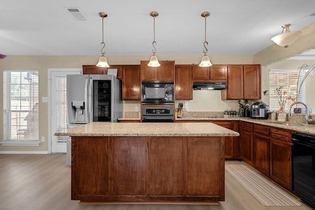7413 Dana Ln, North Richland Hills, TX 76182 - kitchen featuring black appliances, a sink, under cabinet range hood, light wood-style flooring, and a kitchen island