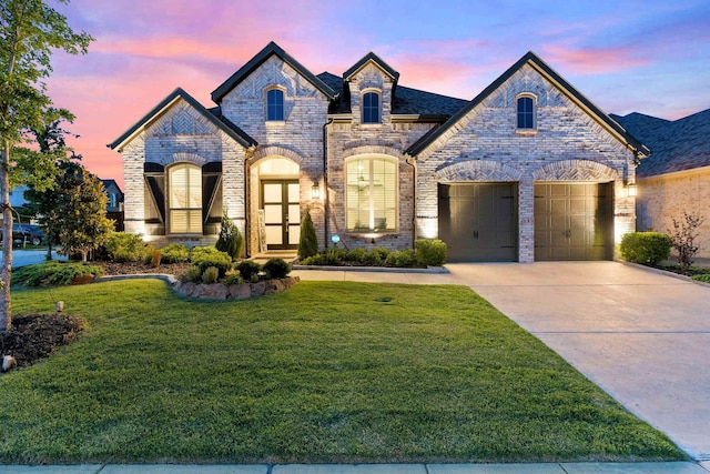 4124 Sandbrock Pkwy, Aubrey, TX 76227 - french country inspired facade featuring a yard, driveway, brick siding, and an attached garage