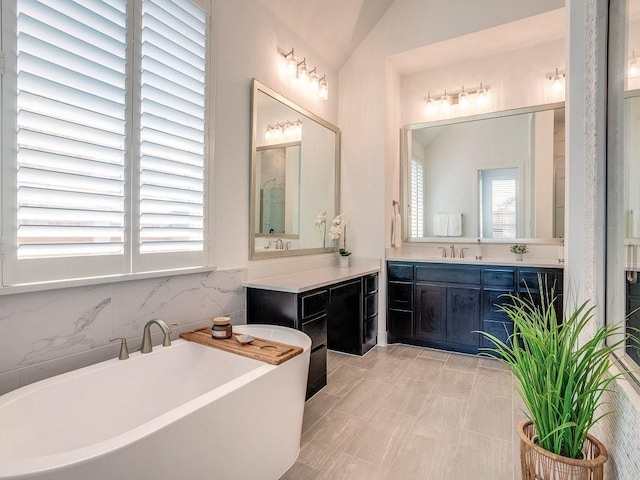 4124 Sandbrock Pkwy, Aubrey, TX 76227 - bathroom with a soaking tub, vanity, and tasteful backsplash
