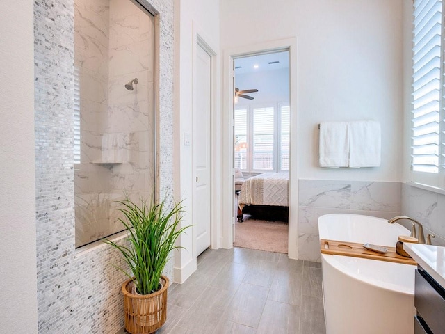 4124 Sandbrock Pkwy, Aubrey, TX 76227 - ensuite bathroom featuring a soaking tub, tile walls, vanity, a shower, and ceiling fan