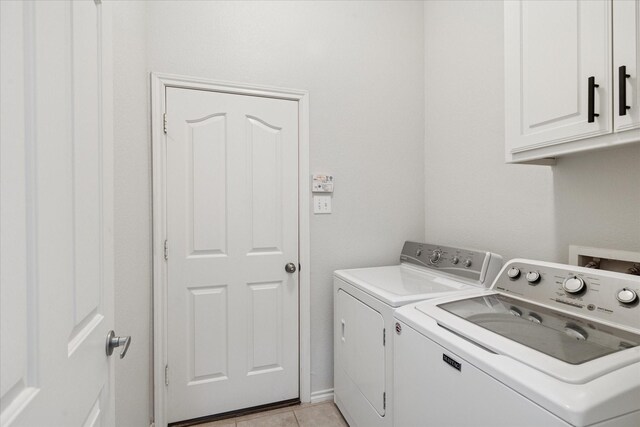 10237 Red Bluff Ln, Fort Worth, TX 76177 - laundry area with cabinet space, washing machine and clothes dryer, and light tile patterned floors