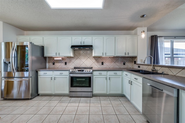4178 Parterre Dr, Frisco, TX 75033 - kitchen with appliances with stainless steel finishes, under cabinet range hood, a sink, white cabinets, and decorative backsplash