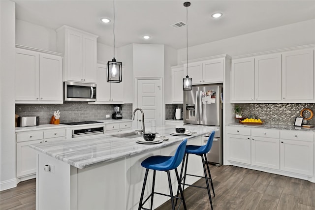 2512 Bunker Hill Dr, Burleson, TX 76028 - kitchen with stainless steel appliances, a sink, wood finished floors, tasteful backsplash, and white cabinetry