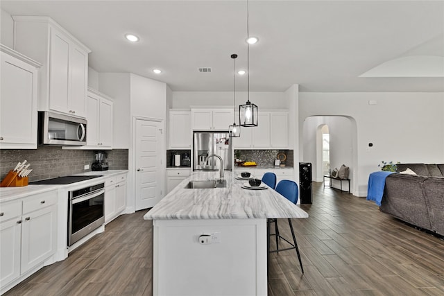 2512 Bunker Hill Dr, Burleson, TX 76028 - kitchen with appliances with stainless steel finishes, open floor plan, arched walkways, a kitchen breakfast bar, and a sink