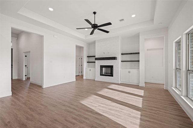 7009 Ranch View Pl, Springtown, TX 76082 - unfurnished living room with a raised ceiling, plenty of natural light, ceiling fan, a fireplace, and recessed lighting