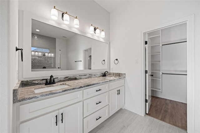 7009 Ranch View Pl, Springtown, TX 76082 - bathroom with double vanity, a spacious closet, a tile shower, and baseboards