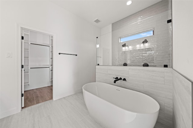 7009 Ranch View Pl, Springtown, TX 76082 - full bath with a freestanding tub, a walk in closet, baseboards, and tile walls