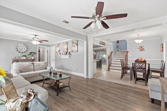 427 Paddy St, Mesquite, TX 75149 - living area with a ceiling fan, stairway, wood finished floors, a textured ceiling, and crown molding