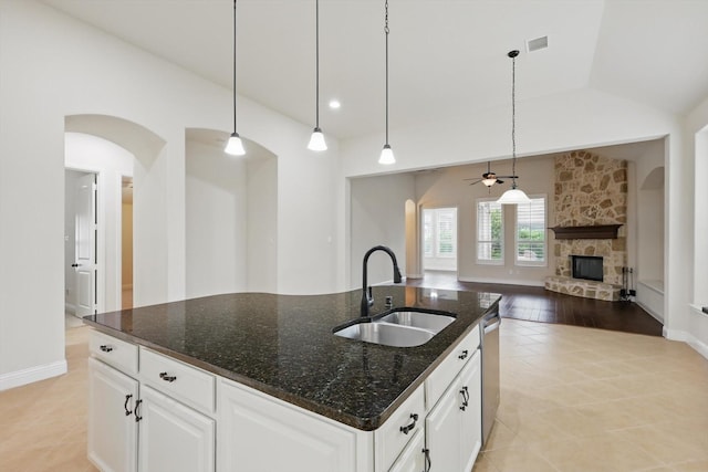 869 Field Xing, Little Elm, TX 76227 - kitchen with a ceiling fan, a stone fireplace, arched walkways, open floor plan, and stainless steel dishwasher