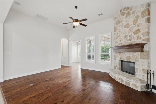 869 Field Xing, Little Elm, TX 76227 - unfurnished living room featuring a fireplace, ceiling fan, hardwood / wood-style floors, and arched walkways