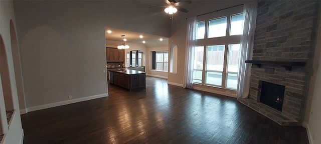1094 Canterbury Ln, Forney, TX 75126 - living area featuring ceiling fan, arched walkways, baseboards, a fireplace, and healthy amount of natural light