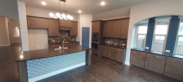 1094 Canterbury Ln, Forney, TX 75126 - kitchen featuring stainless steel appliances, dark countertops, a sink, backsplash, and dark wood finished floors