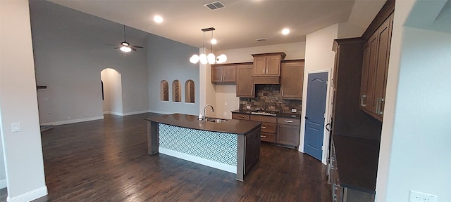 1094 Canterbury Ln, Forney, TX 75126 - kitchen featuring dark countertops, arched walkways, backsplash, ceiling fan, and dark wood-type flooring