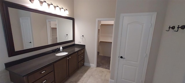 1094 Canterbury Ln, Forney, TX 75126 - bathroom featuring vanity, a walk in closet, baseboards, and tile patterned floors