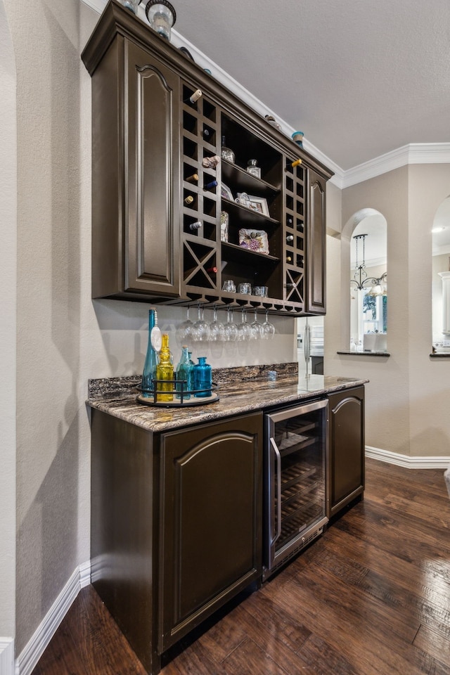 5005 Summerbrook Dr, Colleyville, TX 76034 - indoor dry bar with beverage cooler, baseboards, crown molding, dark wood finished floors, and arched walkways
