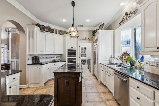 5005 Summerbrook Dr, Colleyville, TX 76034 - kitchen with appliances with stainless steel finishes, arched walkways, backsplash, crown molding, and a sink