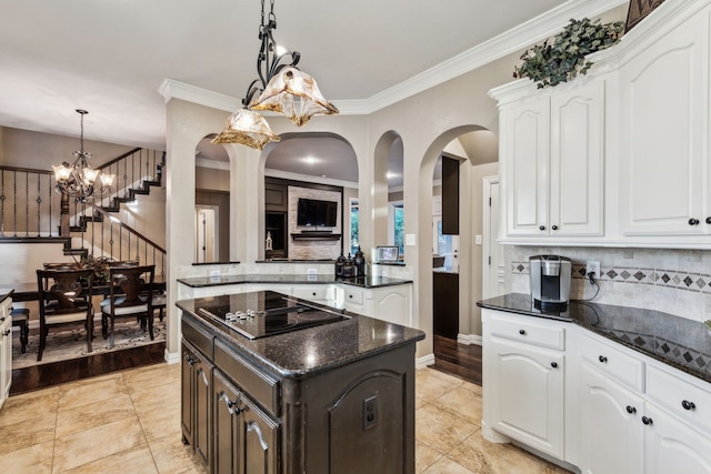 5005 Summerbrook Dr, Colleyville, TX 76034 - kitchen featuring black electric cooktop, arched walkways, decorative backsplash, dark stone countertops, and crown molding
