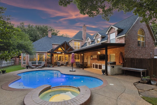 5005 Summerbrook Dr, Colleyville, TX 76034 - back of house featuring brick siding, exterior kitchen, a fenced backyard, a patio area, and a pool with connected hot tub