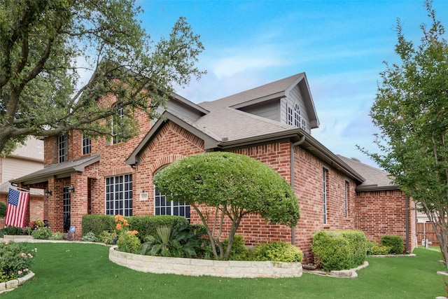 6702 Amesbury Ln, Rowlett, TX 75089 - view of home's exterior featuring brick siding, a lawn, and roof with shingles