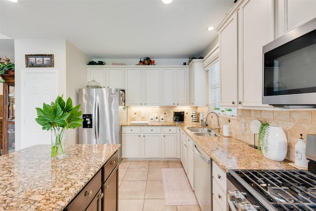 6702 Amesbury Ln, Rowlett, TX 75089 - kitchen with stainless steel appliances, a sink, tasteful backsplash, light tile patterned floors, and light stone countertops