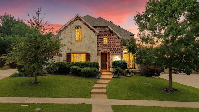 631 Rock Hill Rd, Prosper, TX 75078 - french country inspired facade featuring stone siding, a lawn, a shingled roof, and brick siding