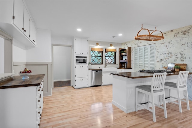 2607 Glendale Dr, Waco, TX 76710 - kitchen featuring stainless steel appliances, wood counters, a sink, light wood finished floors, and recessed lighting