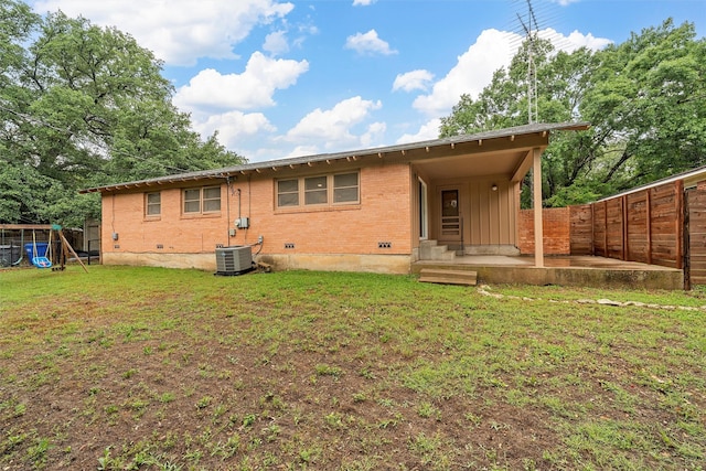 2607 Glendale Dr, Waco, TX 76710 - rear view of house with central AC unit, brick siding, a playground, a patio area, and board and batten siding