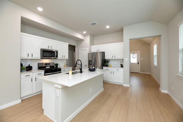 222 Goosewood Dr, Mckinney, TX 75071 - kitchen with stainless steel appliances, a sink, decorative backsplash, an island with sink, and light wood finished floors