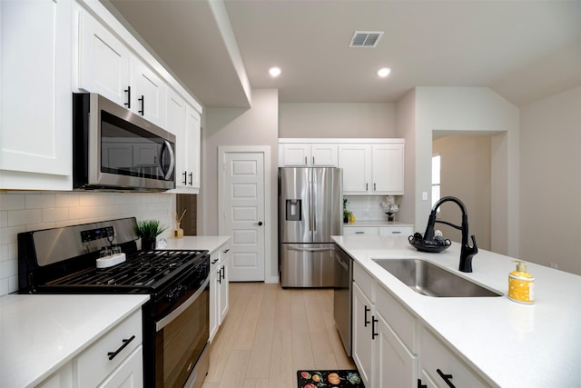 222 Goosewood Dr, Mckinney, TX 75071 - kitchen featuring appliances with stainless steel finishes, a sink, white cabinets, light countertops, and tasteful backsplash