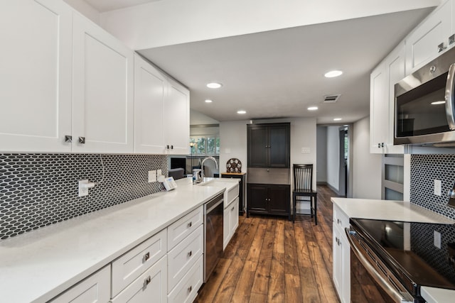 12217 Veronica Rd, Farmers Branch, TX 75234 - kitchen with stainless steel appliances, dark wood-style flooring, decorative backsplash, light countertops, and recessed lighting