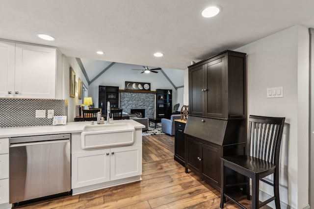 12217 Veronica Rd, Farmers Branch, TX 75234 - kitchen with dishwasher, a sink, ceiling fan, a peninsula, and light wood-type flooring