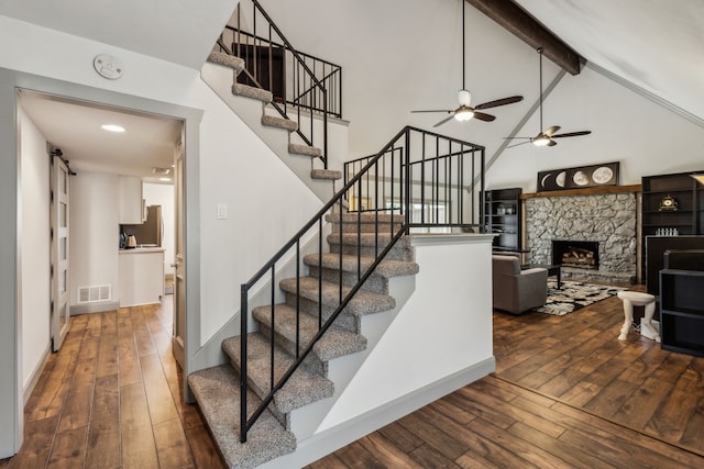 12217 Veronica Rd, Farmers Branch, TX 75234 - stairway with hardwood / wood-style flooring, ceiling fan, beam ceiling, a fireplace, and high vaulted ceiling