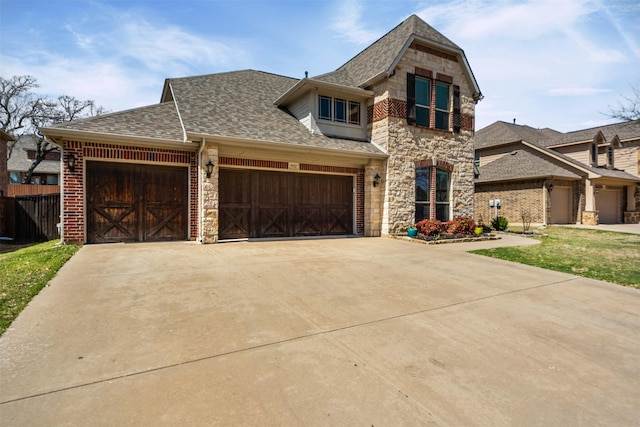 952 Tara Dr, Burleson, TX 76028 - view of front facade featuring stone siding, roof with shingles, a garage, concrete driveway, and brick siding