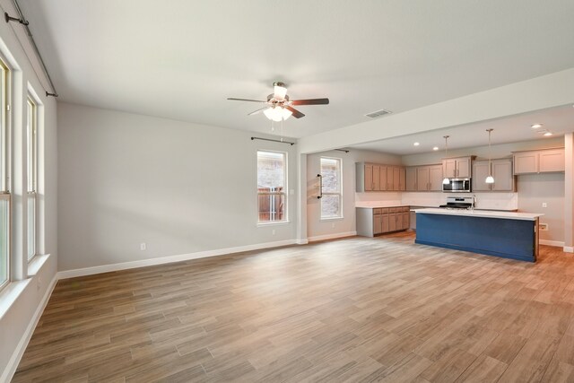 524 Big Horn Pass, Denton, TX 76210 - kitchen featuring stainless steel microwave, baseboards, light countertops, a ceiling fan, and stove