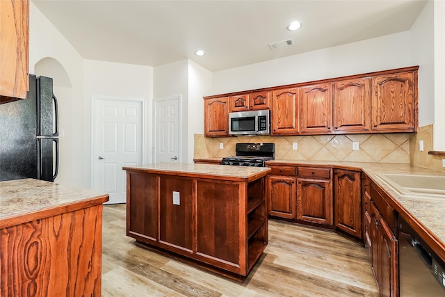1012 Fairweather Dr, Fort Worth, TX 76120 - kitchen with black appliances, light countertops, light wood-type flooring, backsplash, and recessed lighting