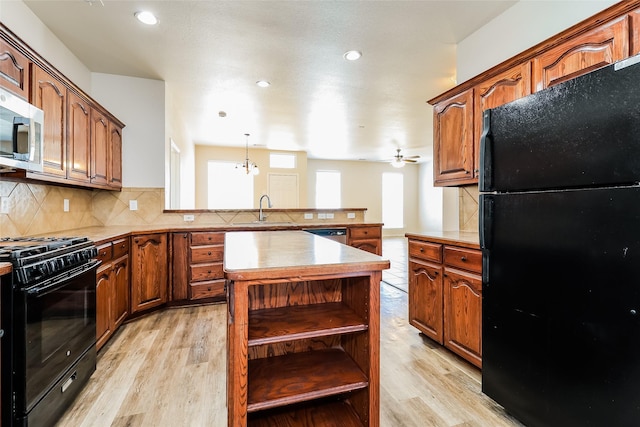 1012 Fairweather Dr, Fort Worth, TX 76120 - kitchen featuring black appliances, a sink, light wood finished floors, a peninsula, and recessed lighting