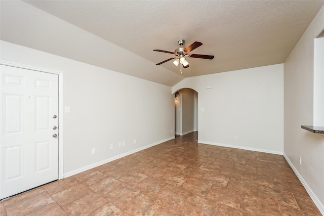 7660 Hollow Forest Dr, Fort Worth, TX 76123 - empty room featuring arched walkways, ceiling fan, stone finish flooring, baseboards, and a textured ceiling