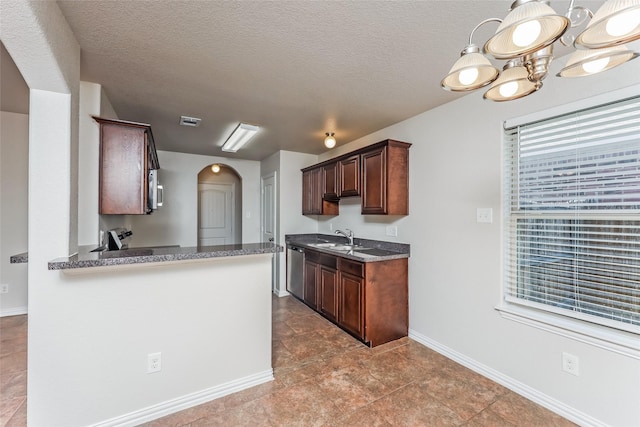 7660 Hollow Forest Dr, Fort Worth, TX 76123 - kitchen with arched walkways, a sink, dishwasher, baseboards, and a textured ceiling
