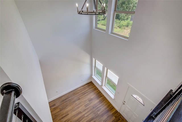 312 Beckham St, Sulphur Springs, TX 75482 - unfurnished living room with a chandelier, wood finished floors, baseboards, and a towering ceiling