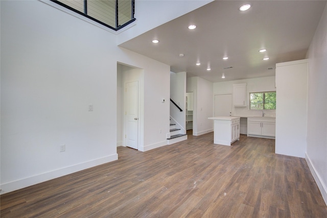312 Beckham St, Sulphur Springs, TX 75482 - unfurnished living room featuring recessed lighting, wood finished floors, stairs, baseboards, and a sink