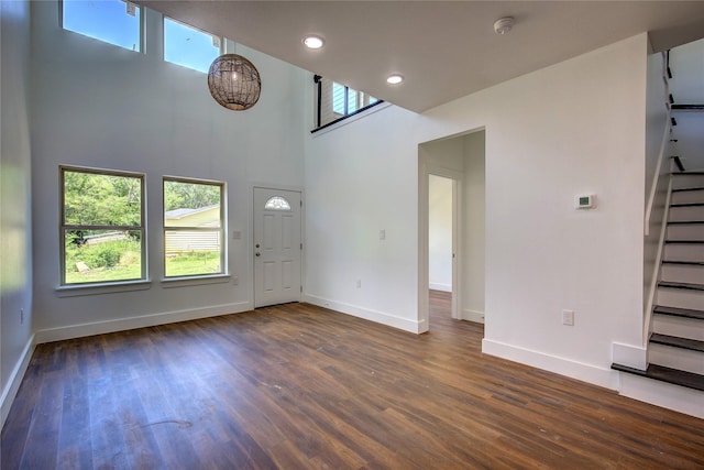 312 Beckham St, Sulphur Springs, TX 75482 - unfurnished living room with stairway, baseboards, dark wood-style floors, a towering ceiling, and recessed lighting