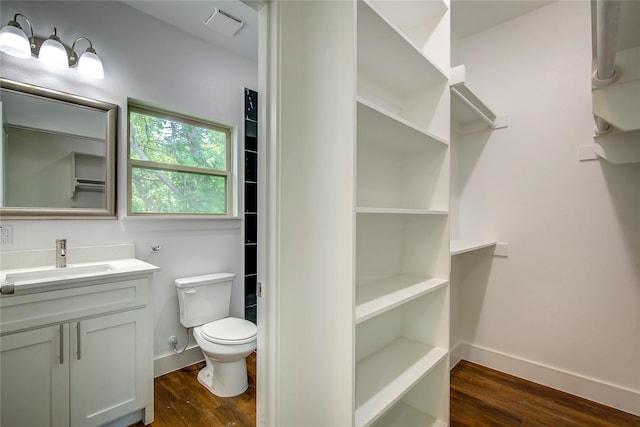 312 Beckham St, Sulphur Springs, TX 75482 - bathroom with wood finished floors, toilet, vanity, and baseboards