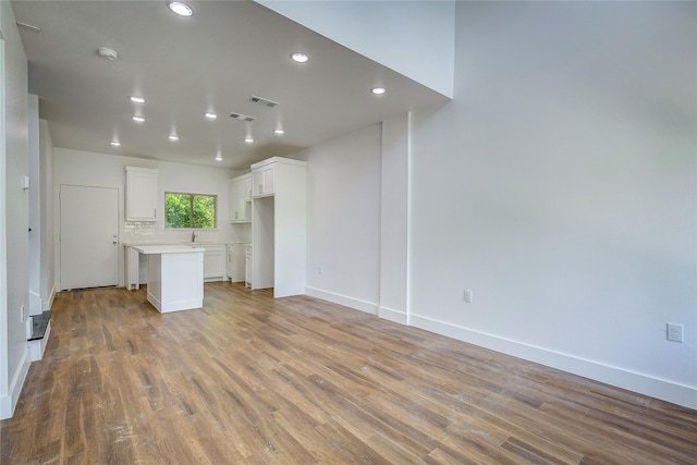 312 Beckham St, Sulphur Springs, TX 75482 - unfurnished living room with light wood-type flooring, recessed lighting, baseboards, and a sink