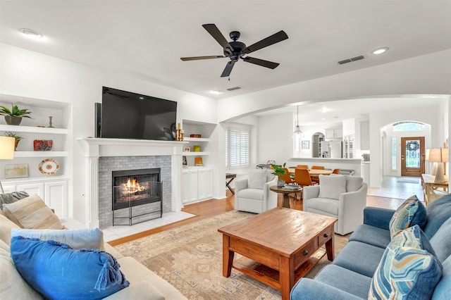 2081 Ashbourne Dr, Rockwall, TX 75087 - living room with healthy amount of natural light, arched walkways, a ceiling fan, built in features, and recessed lighting