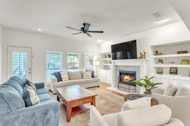 2081 Ashbourne Dr, Rockwall, TX 75087 - living area featuring ceiling fan, light wood finished floors, a brick fireplace, recessed lighting, and built in features